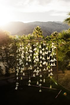 an outdoor ceremony with paper birds hanging from it