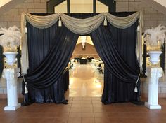 an entrance way with black drapes and white pillars