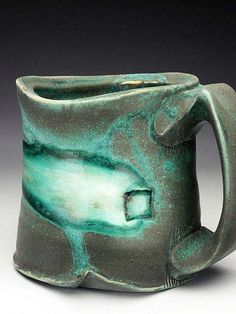 a green and black mug with a handle