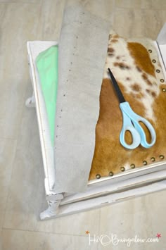 a pair of scissors sitting on top of a piece of cloth next to some fabric