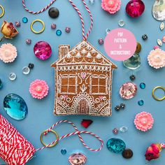 a gingerbread house is surrounded by christmas ornaments and other holiday decorations on a blue background