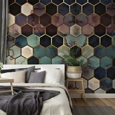 a bed sitting next to a wall covered in lots of hexagonal tiles on it