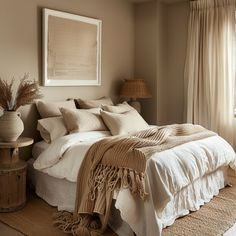 a bed with white linens and pillows in a bedroom next to a large window