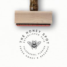 a rubber stamp with a bee on it and the words honey shop written in black ink