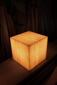 a wooden box sitting on top of a table next to some wood planks in the dark