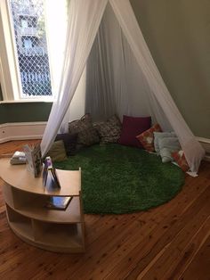 a room with a green rug and white canopy