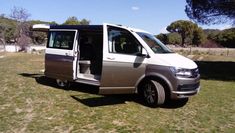 a silver van parked on top of a lush green field