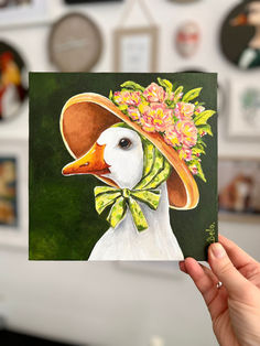 Add elegance and charm to your interior with this square 20x20 cm acrylic painting on canvas. Featuring an elegant Madame Goose adorned with a lovely hat and blooming flowers, this painting adds a touch of sophistication and natural beauty to any room. A unique and expertly crafted piece of art, perfect as a gift for a friend or to decorate your country home. Cute Square Paintings, Painting On Canvas With Acrylic Paint, Cute Square Drawings, Acrylic Painting On Square Canvas, Paintings For Your Mom, Small Square Paintings, Paintings For Best Friends, Small Canvas Ideas, Painting For Mom