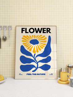 there is a flower poster on the wall next to some coffee cups and mugs