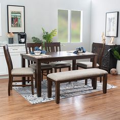 a dinning room table and chairs in front of a window