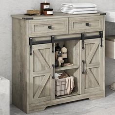 a bathroom cabinet with sliding doors and towels on the top shelf in front of it