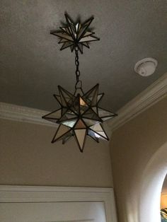 a chandelier hanging from the ceiling in a room with a door and window