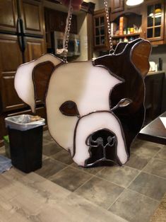 a stained glass dog head hanging from a chain in a kitchen with dark wood cabinets