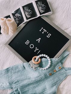 baby clothes and accessories laid out on a bed with the words it's a boy