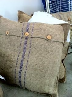 two pillows with buttons on them sitting next to each other in front of a chair