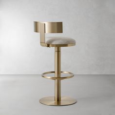 a modern bar stool with a beige upholstered seat and back rests against a white wall