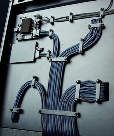 the cables are connected to each other on the side of a metal box with wires attached