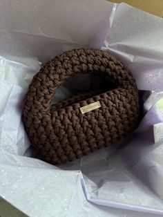 a brown basket sitting on top of white tissue paper