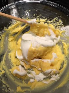 a mixing bowl filled with yellow and white batter