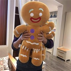 a person holding a large stuffed ginger in their hands and wearing a purple button on the chest