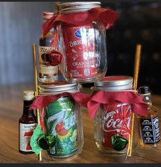 four jars filled with different types of drinks on top of a wooden table next to each other