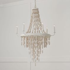 a white chandelier with candles hanging from it's sides in a room