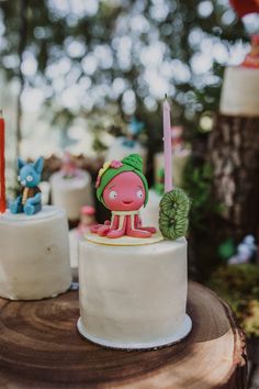 there is a small cake with a pig on it and candles in the shape of animals