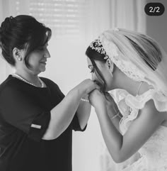 a woman helping another woman put on her wedding dress