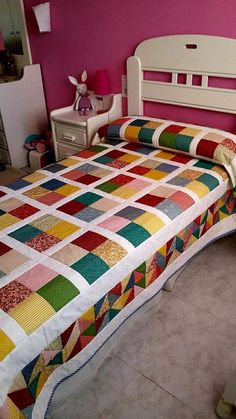 a bed room with a neatly made bed and dressers