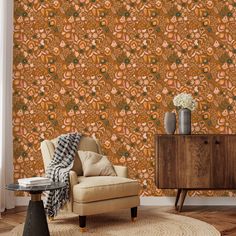 a living room with an orange wallpaper and a chair in front of a table