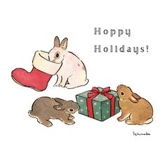 three rabbits are sitting next to a gift box and the words happy holidays written on it