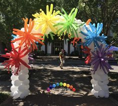 an arch decorated with balloons and streamers in the shape of fireworks on a sunny day