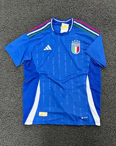 a soccer jersey laying on the ground with it's sleeves folded up to show the italian flag