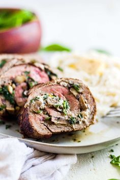 meatloaf with spinach and mushrooms on a white plate