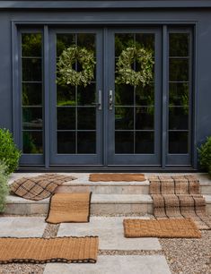 the front door is decorated with wreaths and rugs