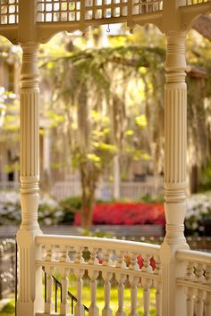 an ornate white gazebo in the middle of a park