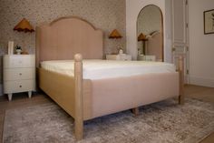 a bedroom with a bed, dresser and mirror in the corner on carpeted floor