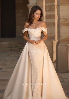 a woman in a wedding dress posing for the camera with her hands on her hips