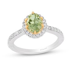 a ring with an oval cut green stone surrounded by white and yellow diamond accents on the band