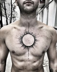 a man's chest with the sun drawn on it, and an arrow in the middle