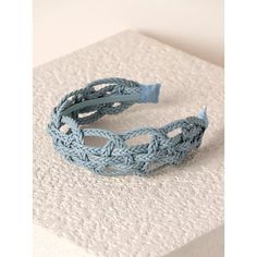 a close up of a blue bracelet on a white surface with an object in the background