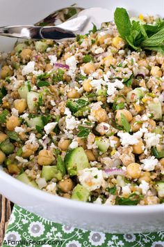 a salad with cucumber, chickpeas and feta cheese in a white bowl