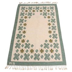 a green and white rug with flowers on it