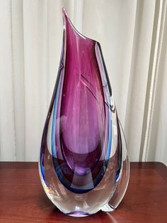 a purple vase sitting on top of a wooden table