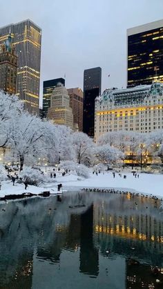 the city is covered in snow and it's lights are on