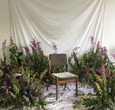 a chair sitting in front of a bunch of flowers