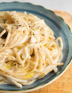 a plate of pasta with white sauce and parmesan cheese