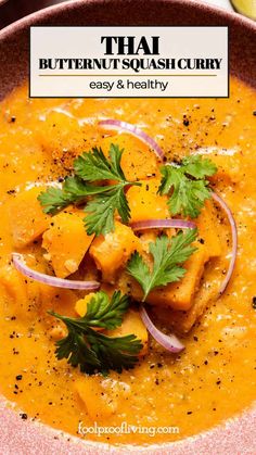 thai butternut squash curry in a pink bowl with cilantro and parsley