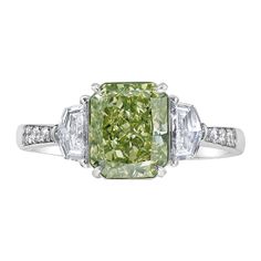 a fancy green diamond ring with three baguets