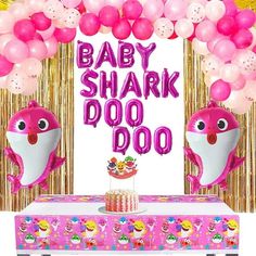 baby shark doooo balloon arch with pink balloons and cupcakes in front of it